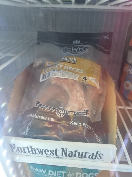 Packaged raw turkey necks in the freezer case, cropped to the product